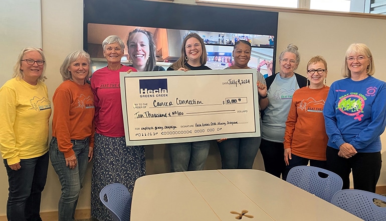 Group of women holding a giant check made out to Cancer Connection