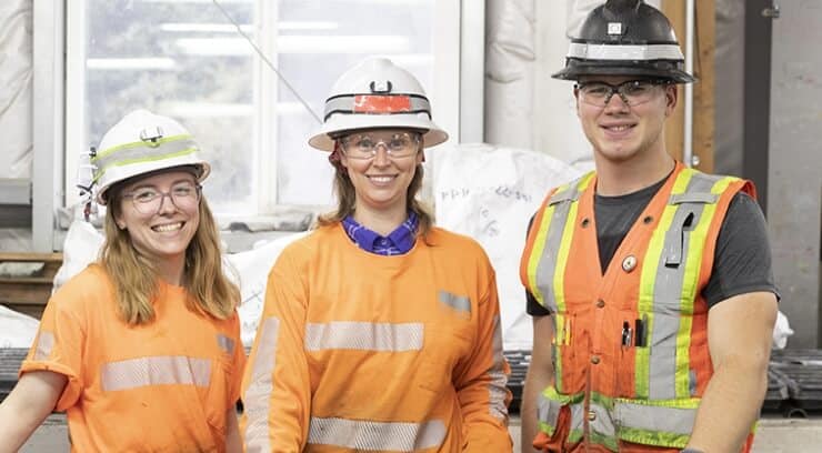 Team members wearing hard hats and safety vests for a group photo