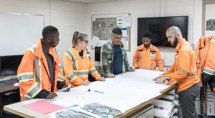 Mining workers looking at schematics at the office